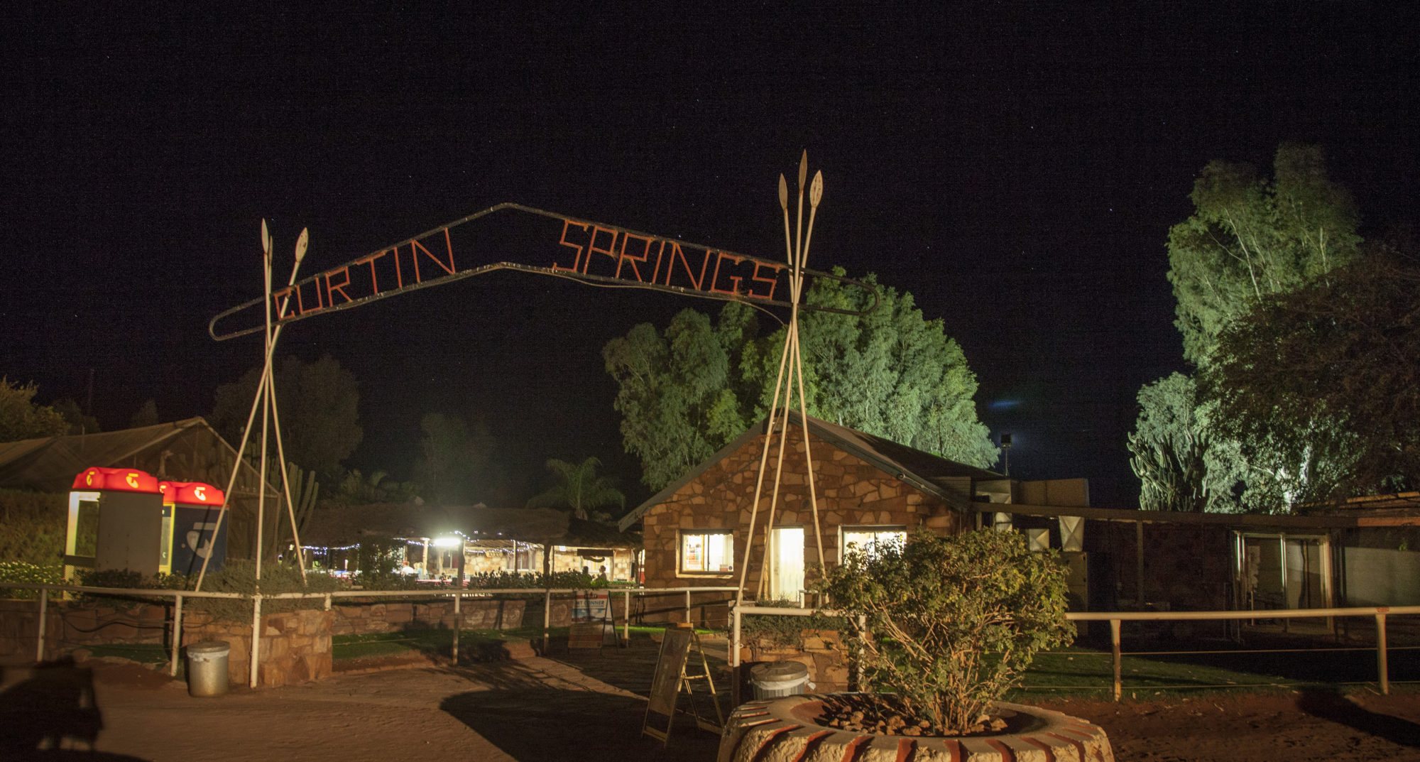 The Curtin Springs entrance arch and Wayside Inn lit up at night