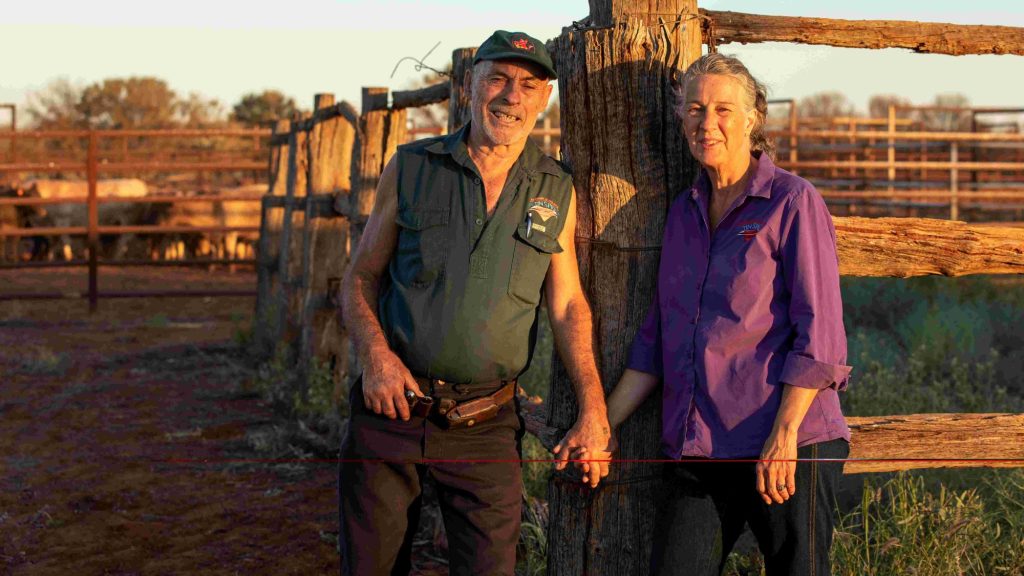 Ashley and Lyndee Severin standing together at a timber cattle yard in evening light