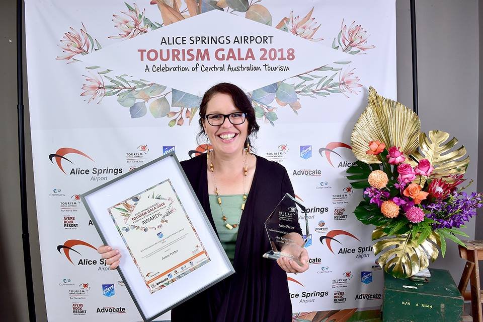 Amee holding award certificates and flowers at the 2018 Tourism Central Australia awards.