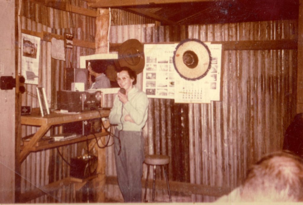 A woman standing at the timber counter inside the early Curtin Springs store