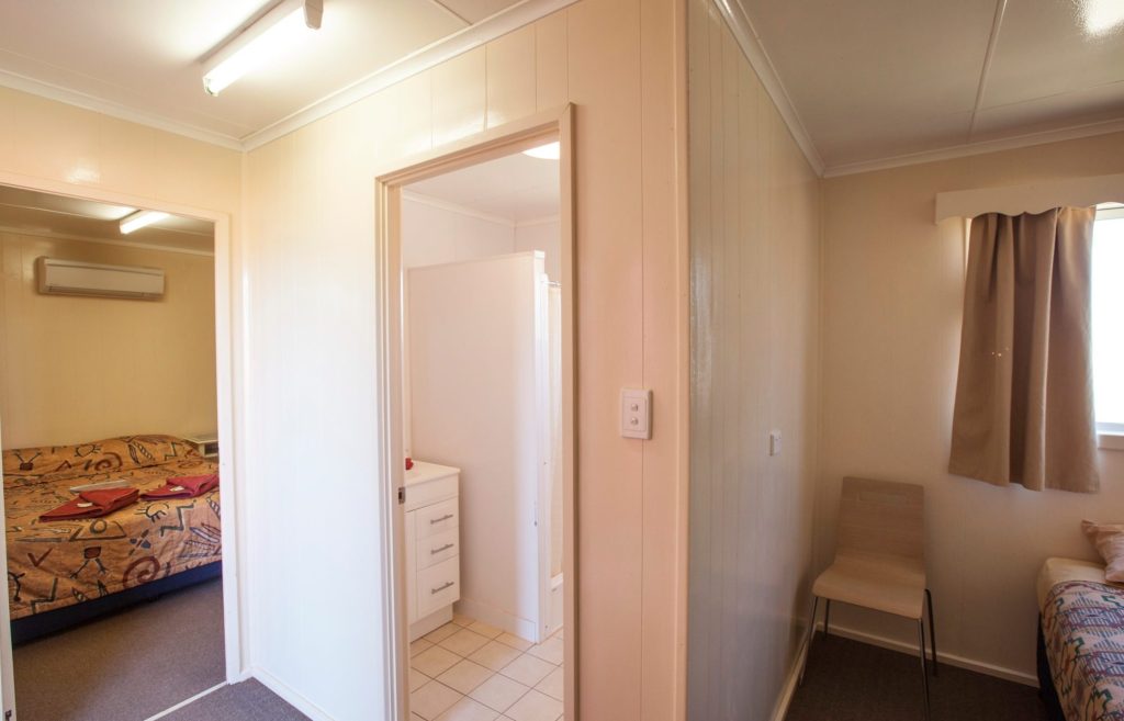 Triple room with a double bed, a separate single bed and a view through to the ensuite